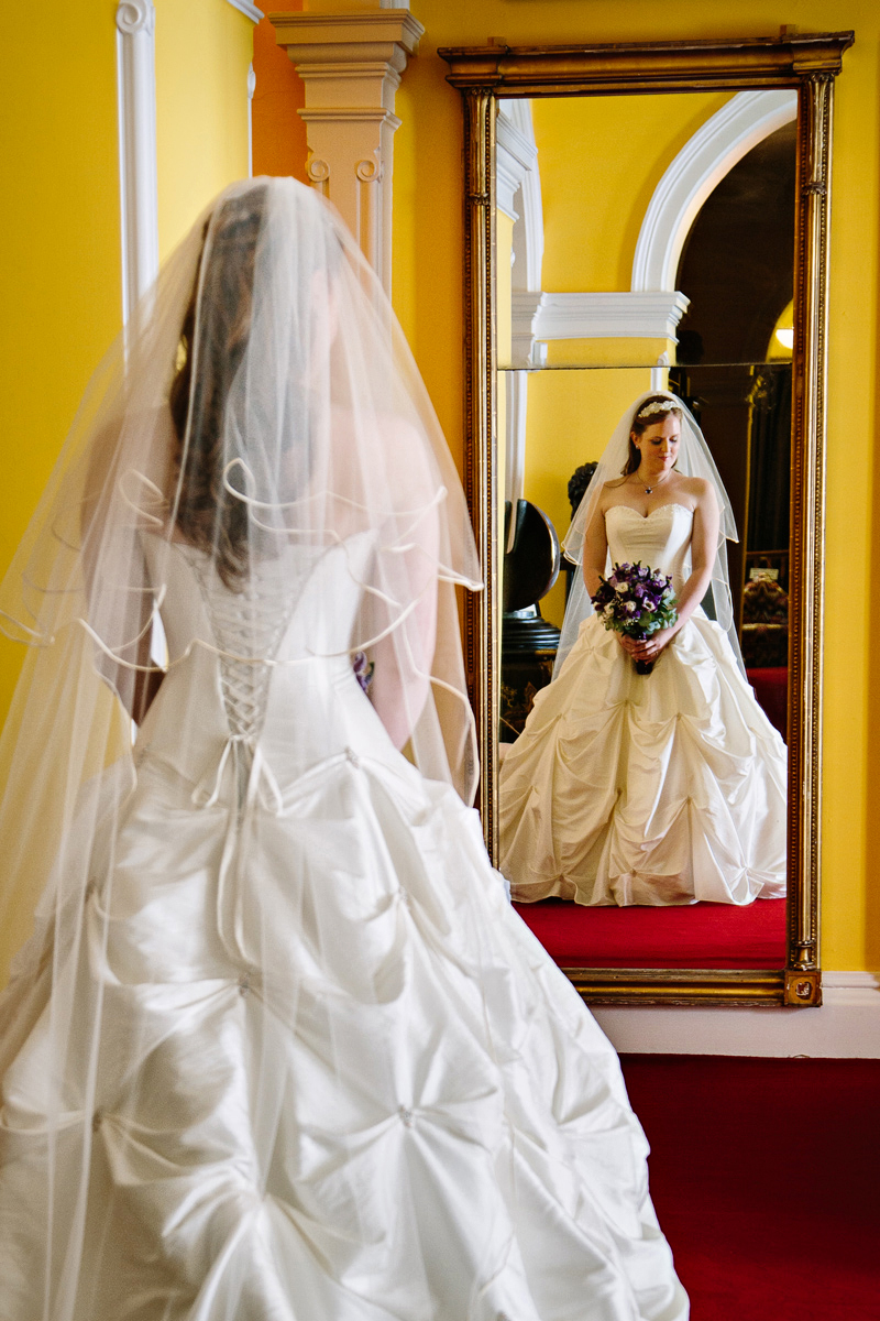 Bride looks at herself in mirror 