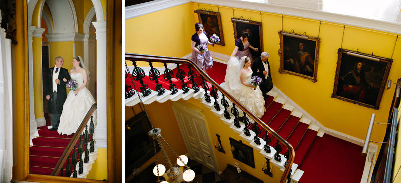 Bride and her dad walk down the staircase to the wedding ceremony