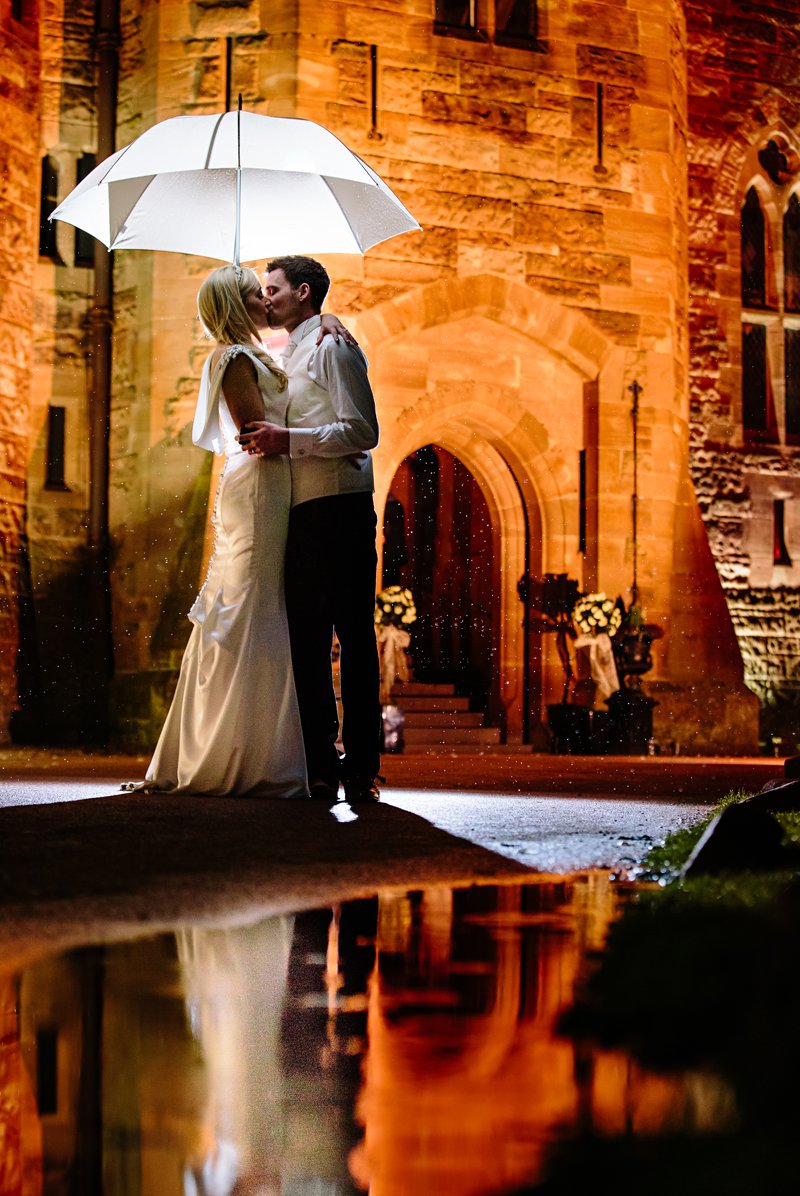 Bride and Groom sharing a kiss under umberella