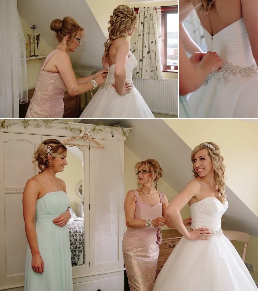 Brides mother helping bride with her wedding dress