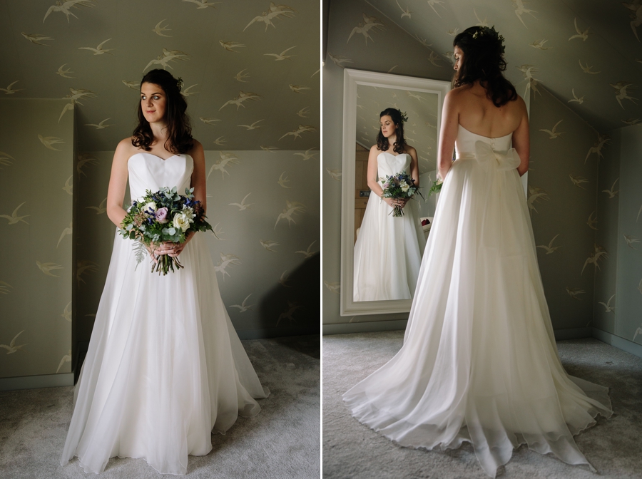 Bride in her wedding dress looking at herself in the mirror