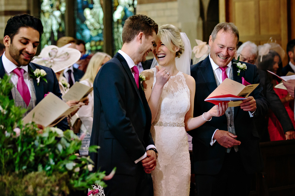 Bride laughing and sharing a moment with the groom in the church