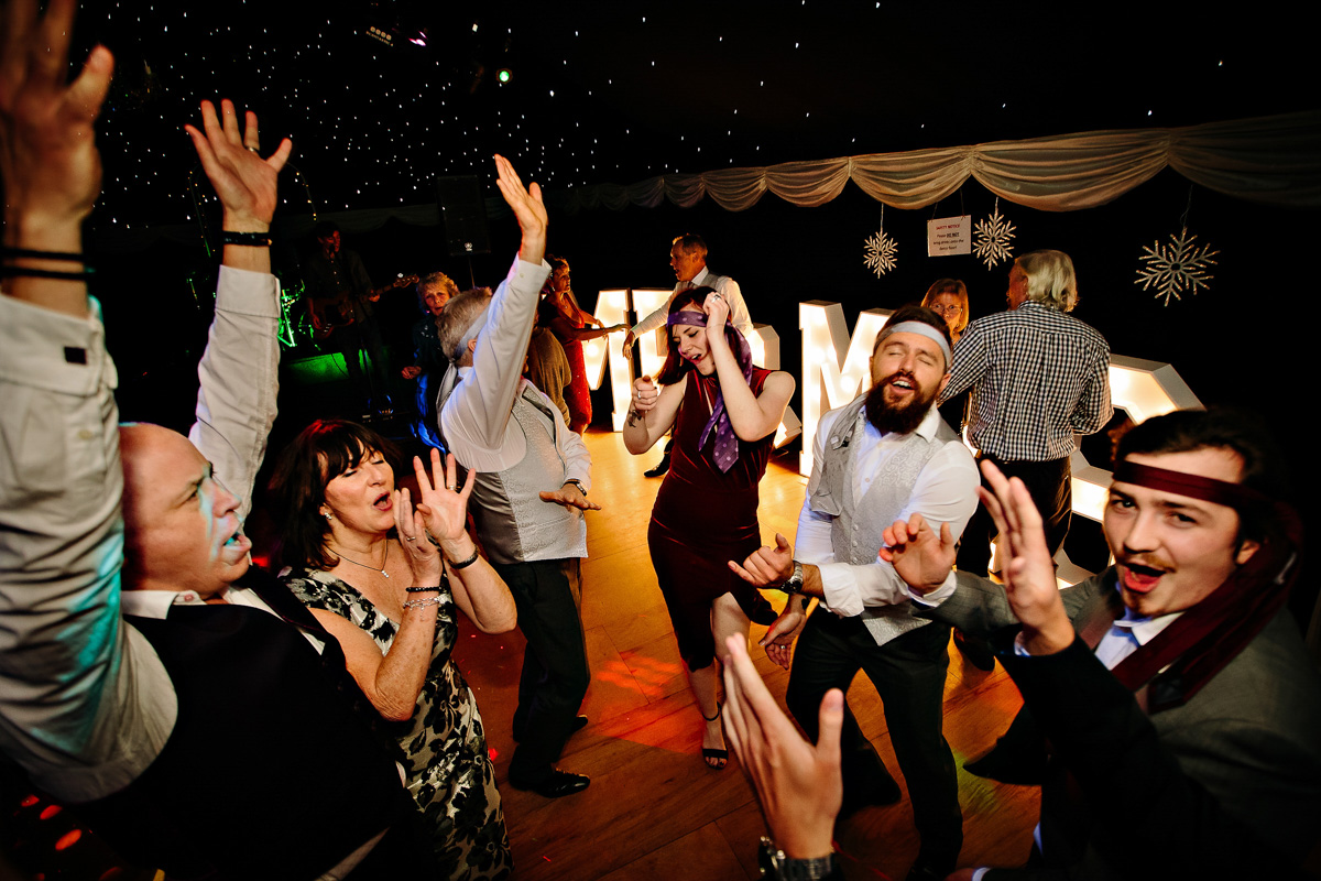 Wedding guests dancing and cheering at the wedding party