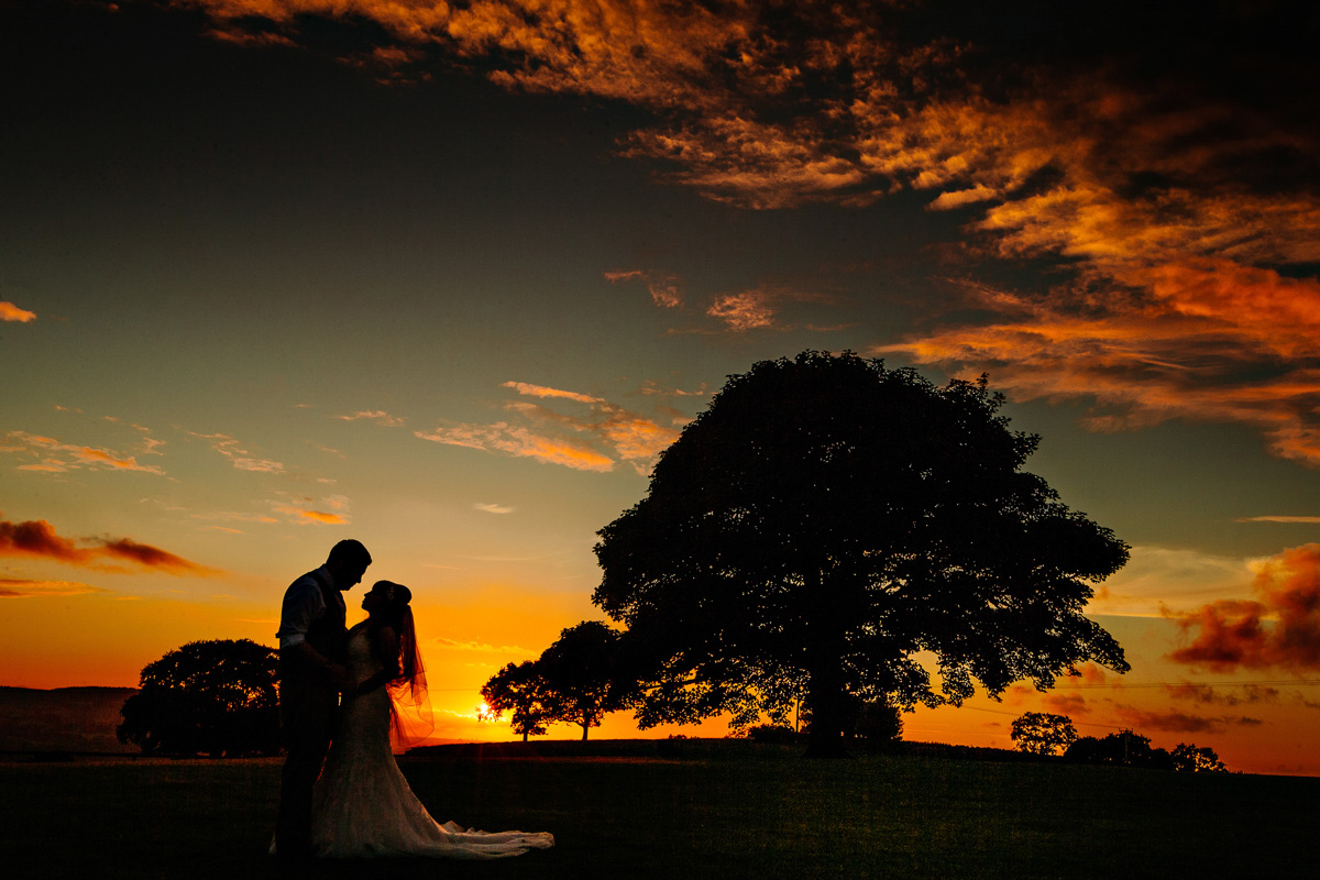 Beautiful sunset silhouette with the bride and groom at Heaton House Farm