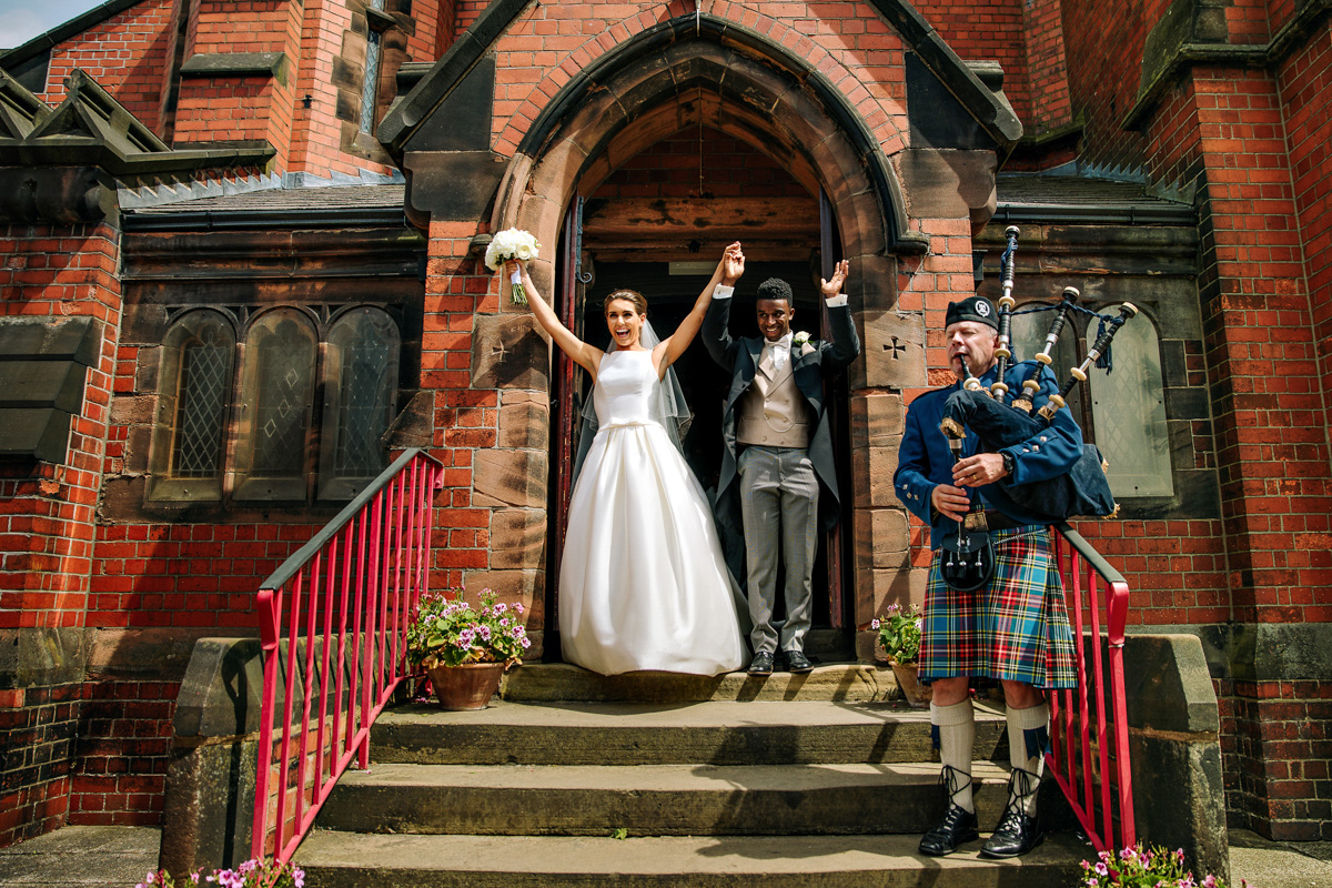 Really happy bride and groom leaving the church with a Scottish piper