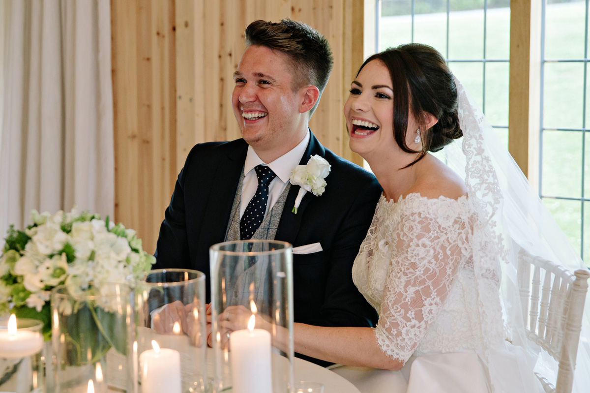 Bride and Groom as they sign the wedding register sharing laughs with guests