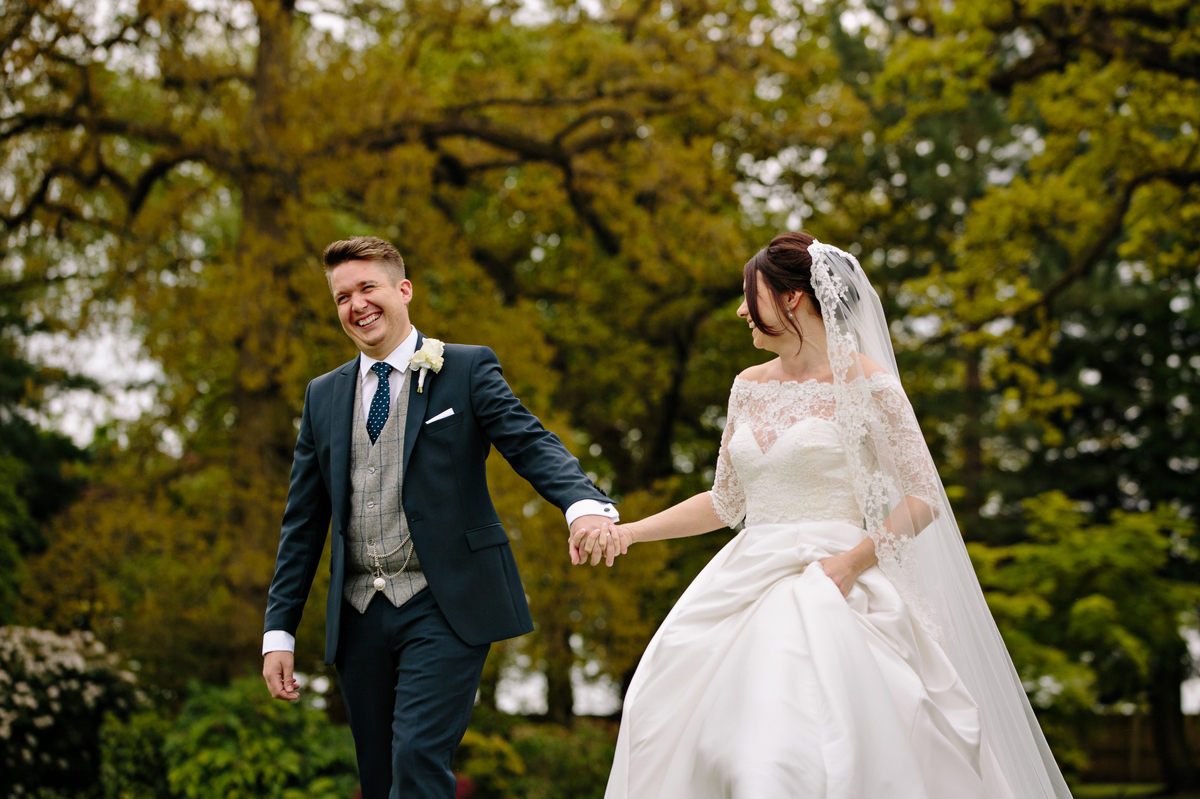 Bride and Groom walking and laughing in the stunning grounds of their wedding venue