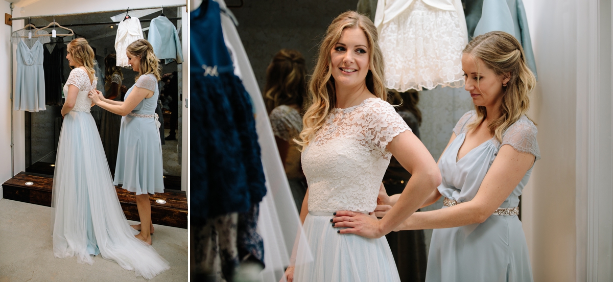 Bridesmaid helping with brides dress