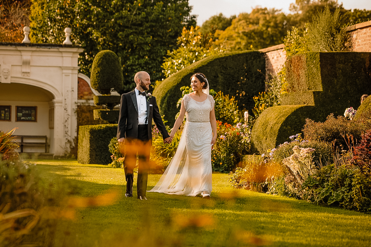 Arley Hall and Gardens with Bride and Groom walking holding hands