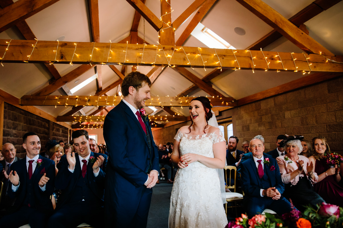 Ceremony and exchanging wedding rings in the rustic barn at Heaton House Farm