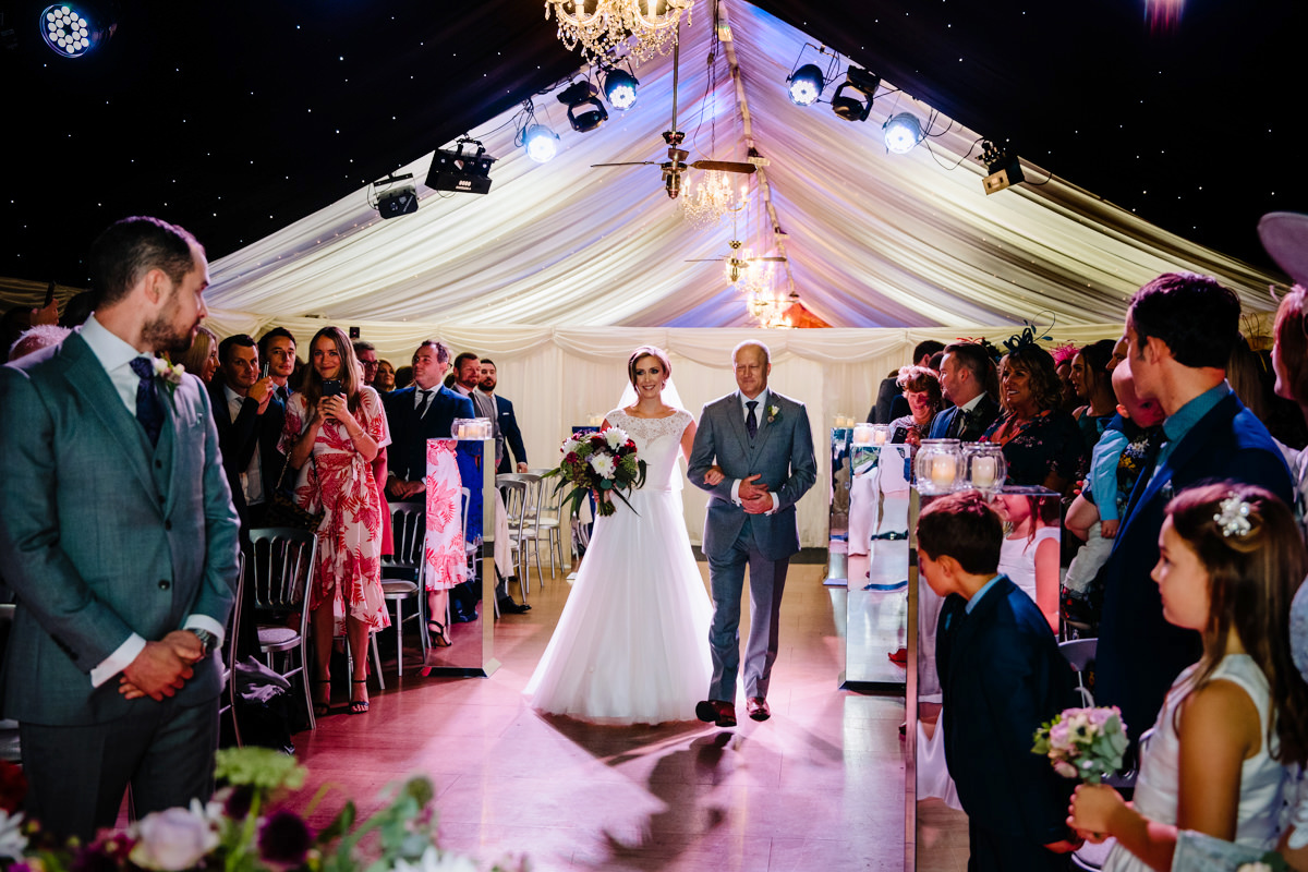 Bride walking down the aisle under the stars at Heaton House Farm