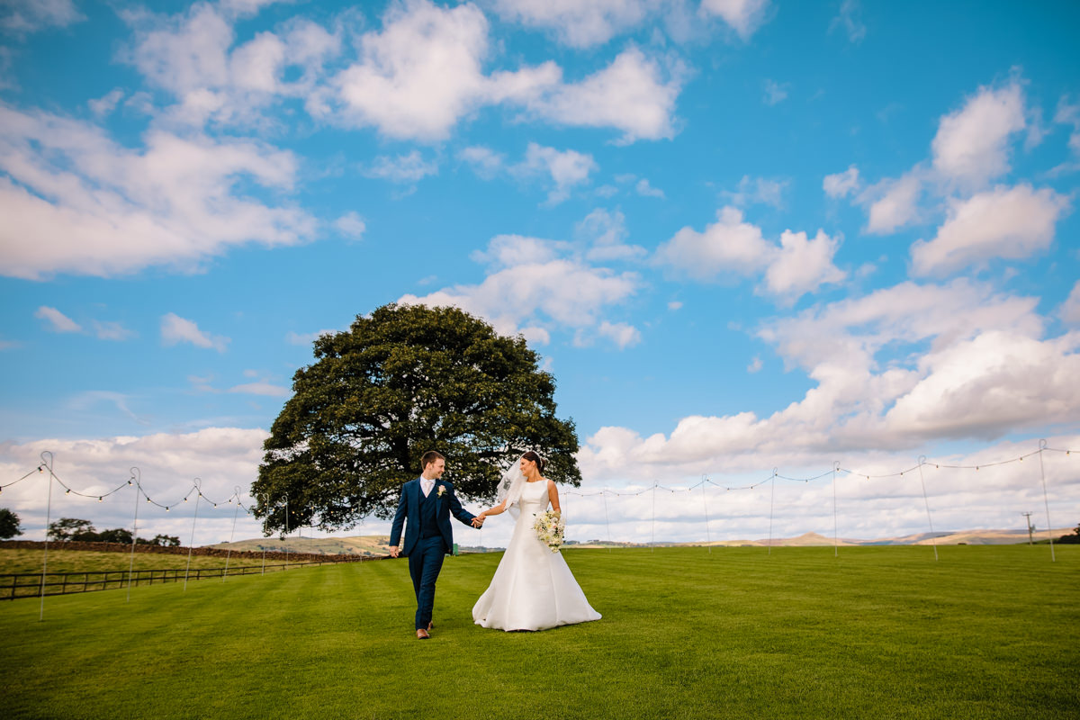 Heaton House Farm Sycamore tree with the Bride and Groom walking hand in hand