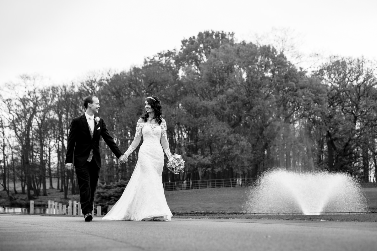 Bride and Groom walking by the fountain at Merrydale Manor