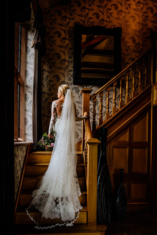 Bride in wedding dress on staircase at Merrydale Manor