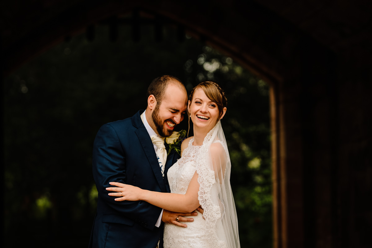 Happy newlyweds laughing together - natural wedding photography