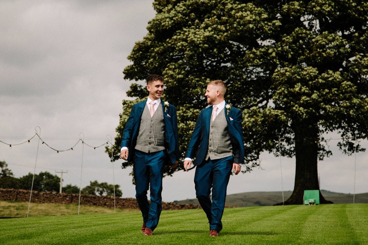 Groom and best man walking at Heaton House Farm