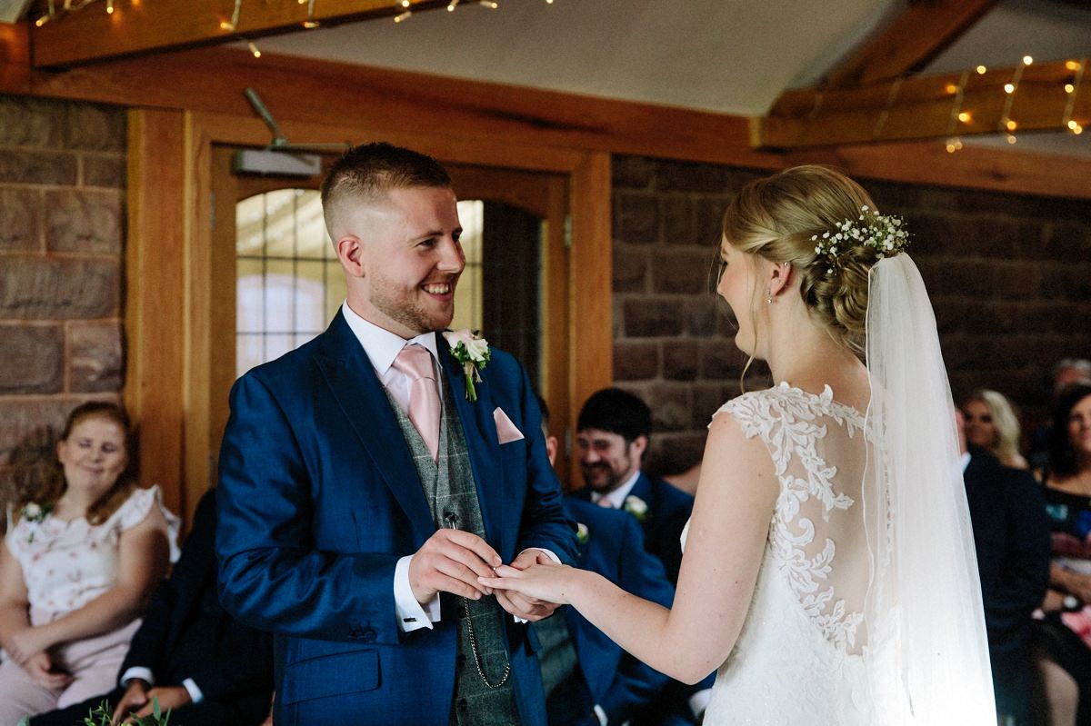 Bride and Groom exchanging wedding rings at Heaton House Farm