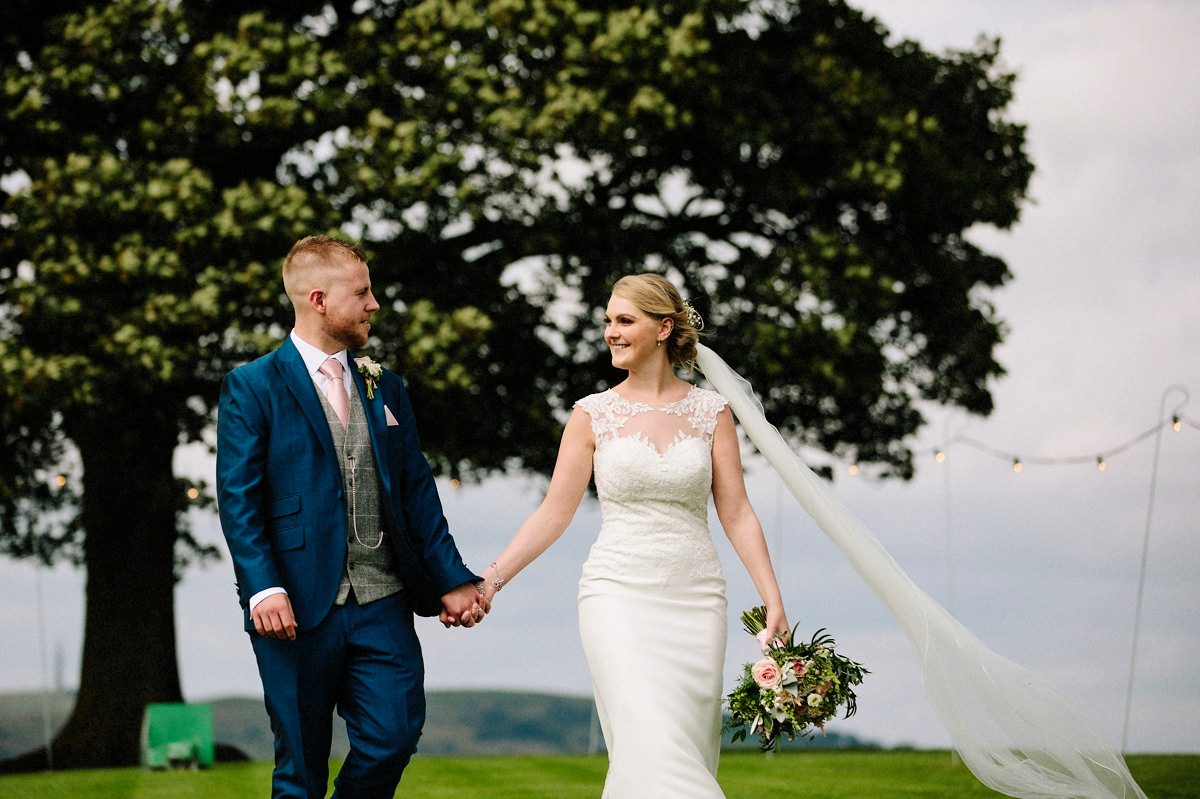 Bride and Groom walking hand in hand at Heaton House Farm