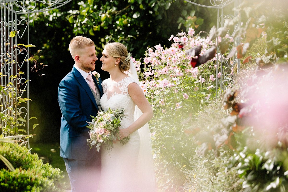 Bride and Groom with pink flowers in the foreground