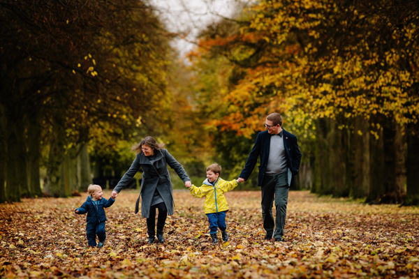 Family walking hand in hand through Marbury Park in Cheshire