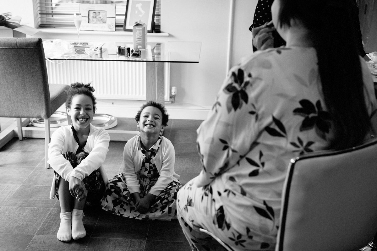 Cute smiling Flower girls watching the bride have her make up applied