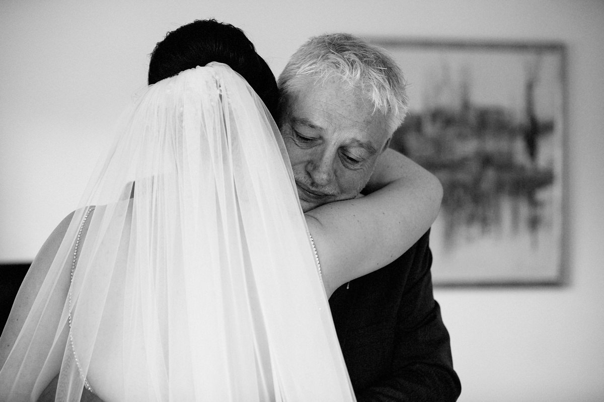 Father of the bride hugging her dad after their first look
