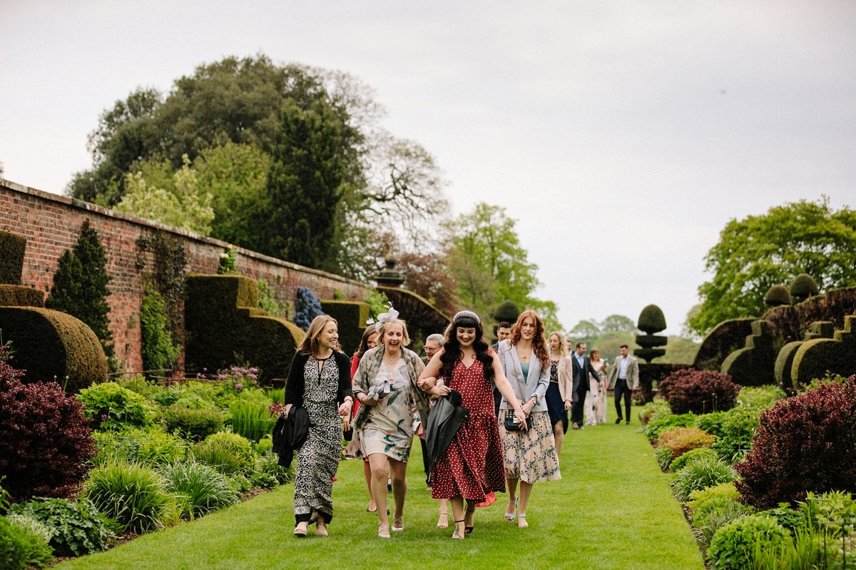 Wedding guests making their way to the alcove for the outdoor wedding ceremony at Arley Hall