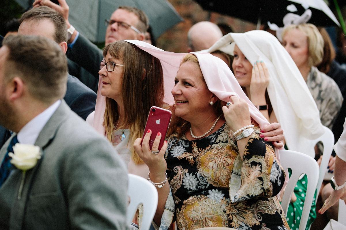 wedding guests sheltering from the rain