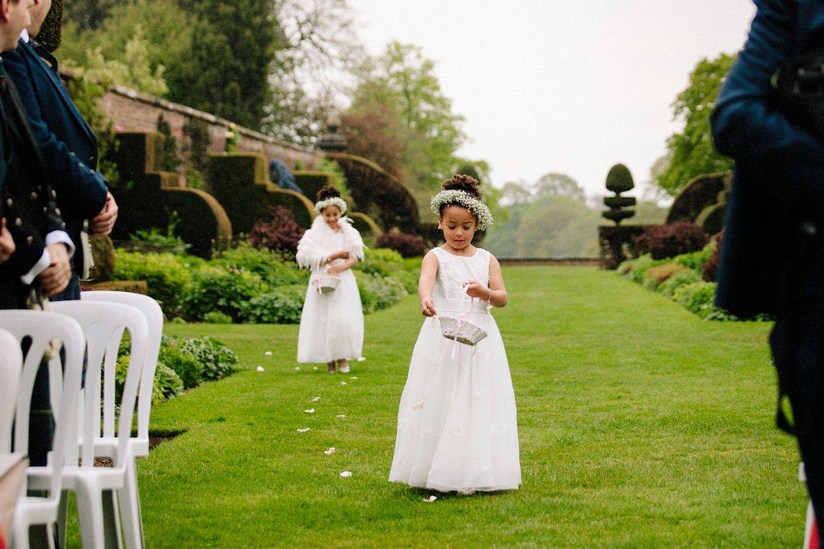 Flower girls showering confetti as they walk down the aisle