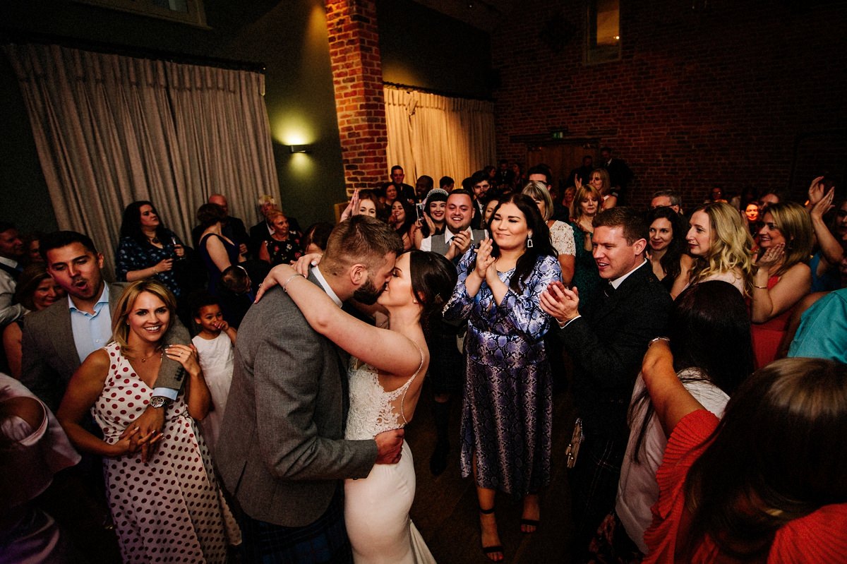 Bride and groom and wedding guests on the dance floor having fun