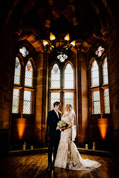 The stained glass window in the great hall with the happy couple at Peckforton Castle