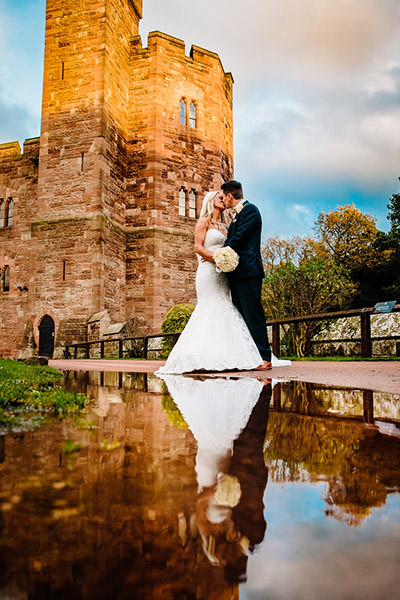 Clever reflection of the bride and groom using a puddle