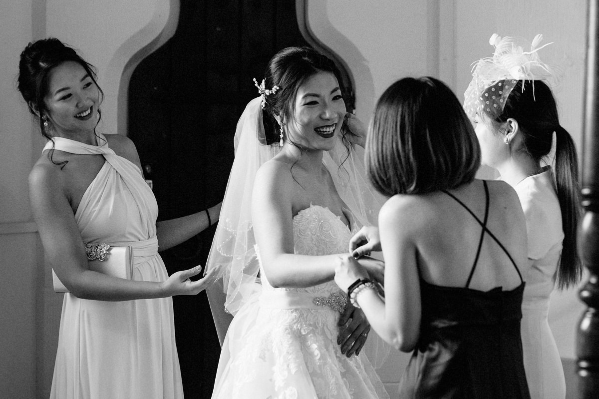 Brides mother helping bride with her wedding dress