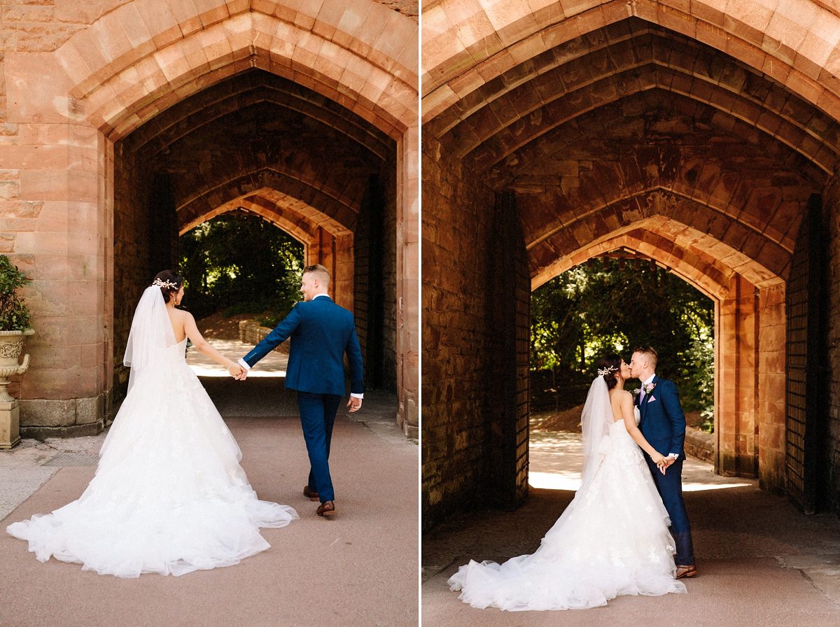 Bride and groom with the drawbridge at Peckforton castle