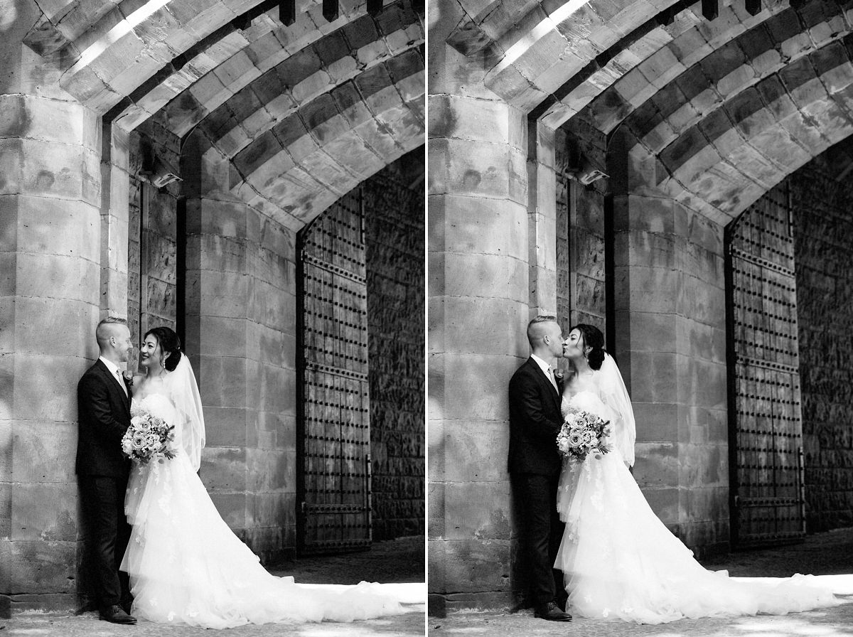 Black & white picture of the bride and groom with the castle walls at Peckforton