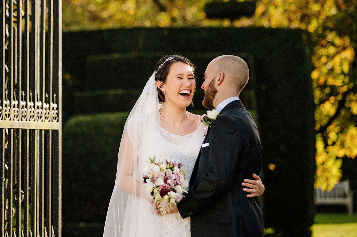 Natural wedding moment of the bride laughing with the groom