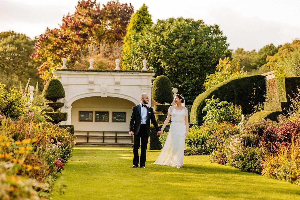 Bride walking with the groom in the gardens at Arley Hall